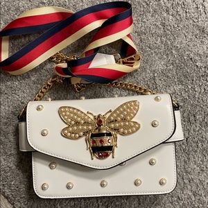 white purse with pearls and detachable ribbon